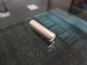 a cylindrical aluminum pin with a 12mm diamter and a length of about 60mm. The edges are rounded over.